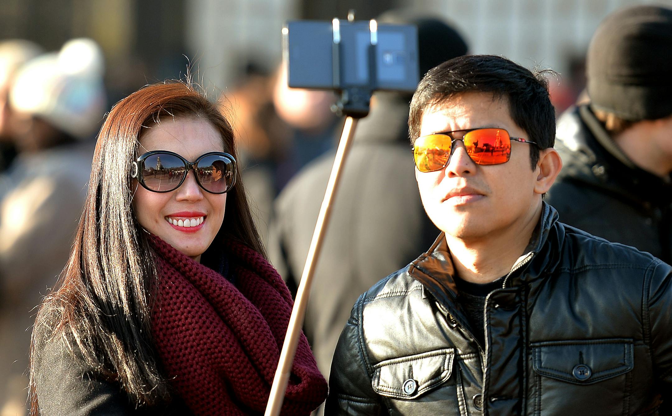 FILE - In this Jan. 23, 2015, file photo, tourists use a 'selfie stick' in London. A French palace and a British museum have joined the growing list of global tourist attractions that have banned �selfie sticks� _ devices visitors use to improve snapshots, but which critics say are obnoxious and potentially dangerous. (AP Photo/PA, John Stillwell) UNITED KINGDOM OUT NO SALES NO ARCHIVE