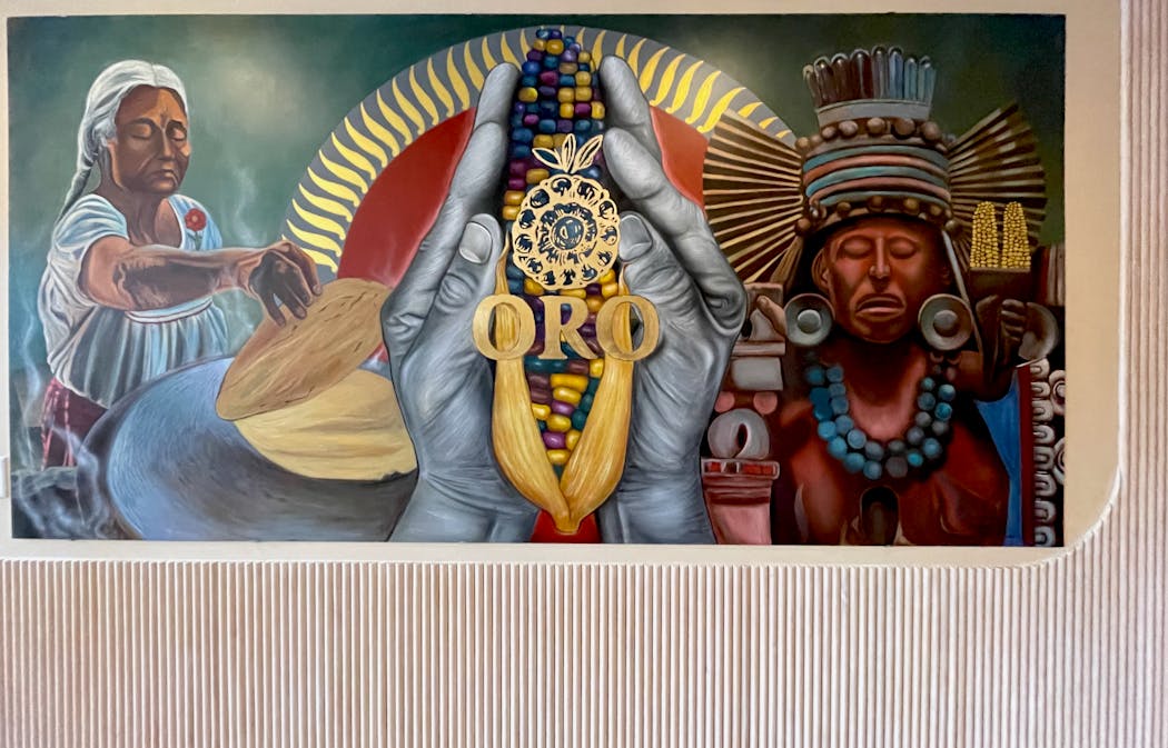 A gilded mural by Gustavo Lira Garcia welcomes guests into Oro.
