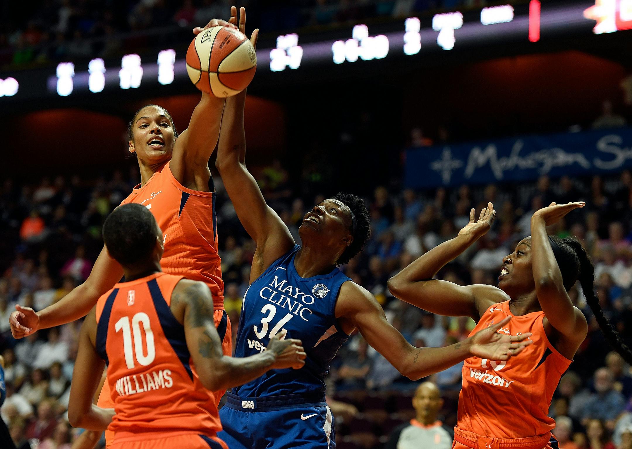 Connecticut Sun forward Alyssa Thomas, top left, beats Minnesota Lynx center Sylvia Fowles (34) to a rebound as Sun guard Courtney Williams (10) and forward Chiney Ogwumike, right, watch during the first half