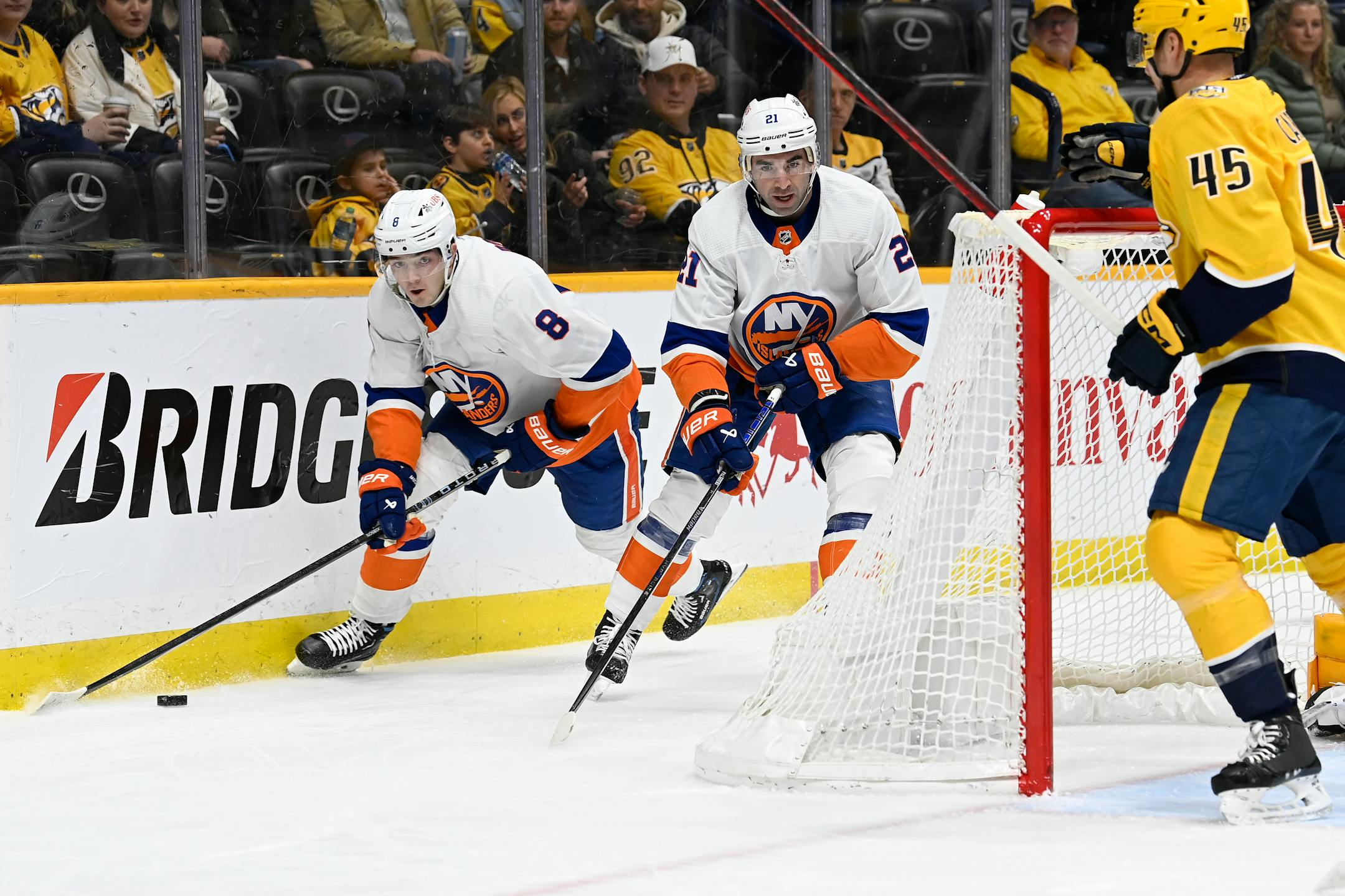 New York Islanders defenseman Noah Dobson (8) moves the puck past center Kyle Palmieri (21) during the first period of the team's NHL hockey game against the Nashville Predators on Saturday, Jan. 13, 2024, in Nashville, Tenn. (AP Photo/Mark Zaleski)