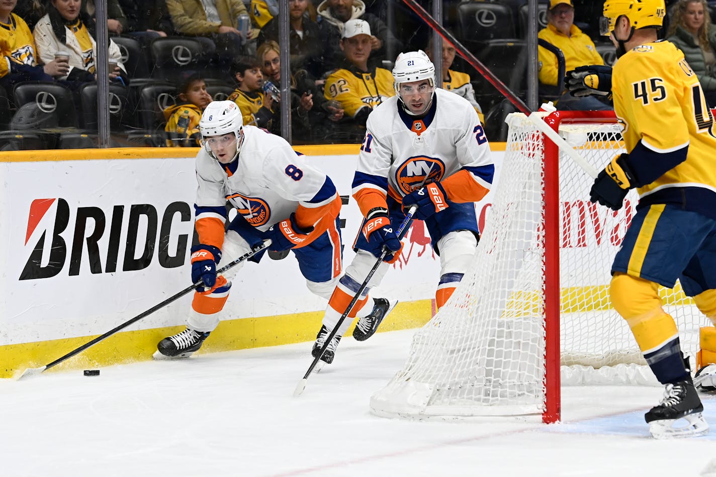 New York Islanders defenseman Noah Dobson (8) moves the puck past center Kyle Palmieri (21) during the first period of the team's NHL hockey game against the Nashville Predators on Saturday, Jan. 13, 2024, in Nashville, Tenn. (AP Photo/Mark Zaleski)