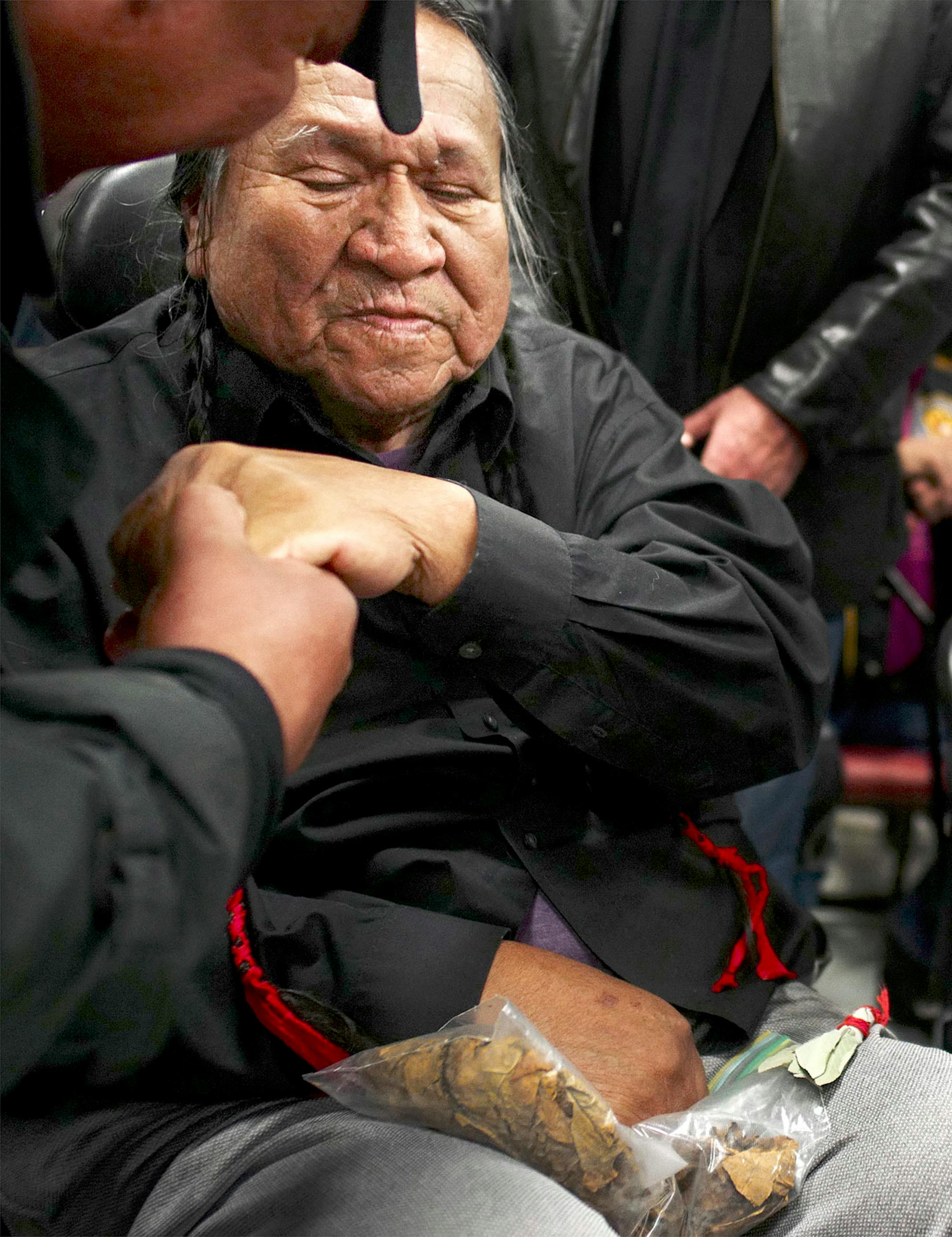 Leonard Crow Dog, one of the founding members of the American Indian Movement, received a gift of tobacco and greeted veterans after an orientation at Sitting Bull College in Fort Yates, N.D.. where veterans arrived at Standing Rock Reservation.