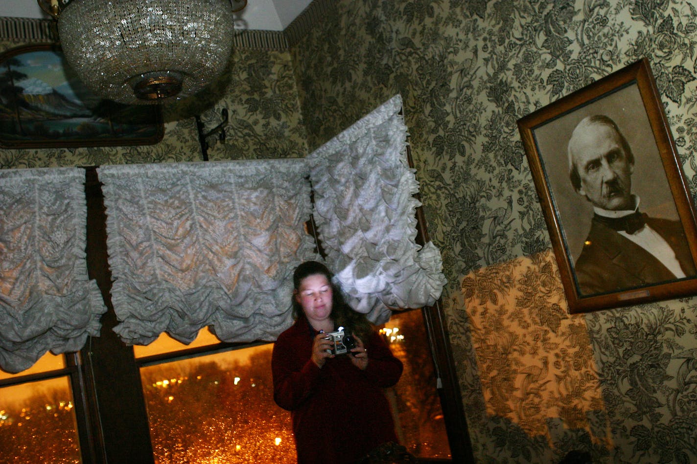 St.Paul,MN;10/29/03:Left to right:Roxanne Kalk, a paranormal investigator uses a digital camera to record the presence of ghosts. A ghost will be evidenced by small orbs in the images. In this room, Molly the maid hung herself.