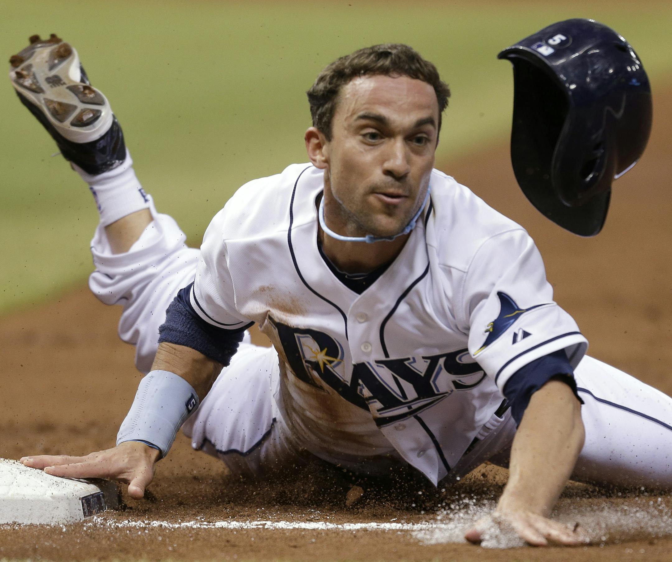 Tampa Bay Rays' Sam Fuld loses his helmet as he dives back safely to first base on a third inning pickoff attempt during a baseball game against the Seattle Mariners Thursday, Aug. 15, 2013, in St. Petersburg, Fla. (AP Photo/Chris O'Meara) ORG XMIT: OTKCO113