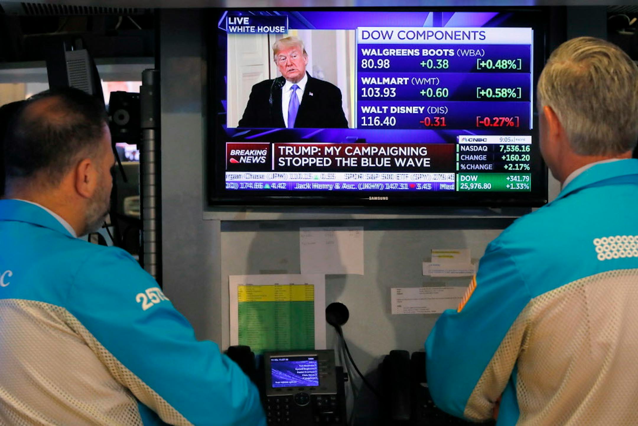 Specialists on the floor of the New York Stock Exchange watch President Donald Trump's news conference Wednesday, Nov. 7, 2018. Technology and health care stocks are leading indexes broadly higher on Wall Street as results of the midterm elections came in largely as investors had expected. (AP Photo/Richard Drew)