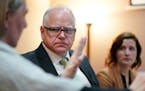 Gov. Tim Walz talked with Catholic Charities navigator Sue Killian during a round table discussion on health care at the Mid-Minnesota Legal Aid in St