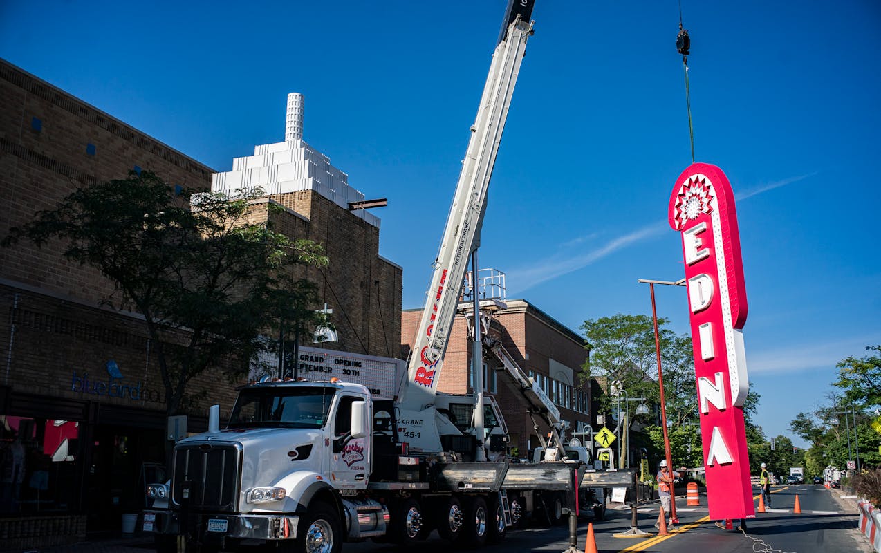 Shad Tracy Signs workers install the Edina Theatre sign on Aug. 29 in Edina. The remodeled theater will reopen on Sept. 30.