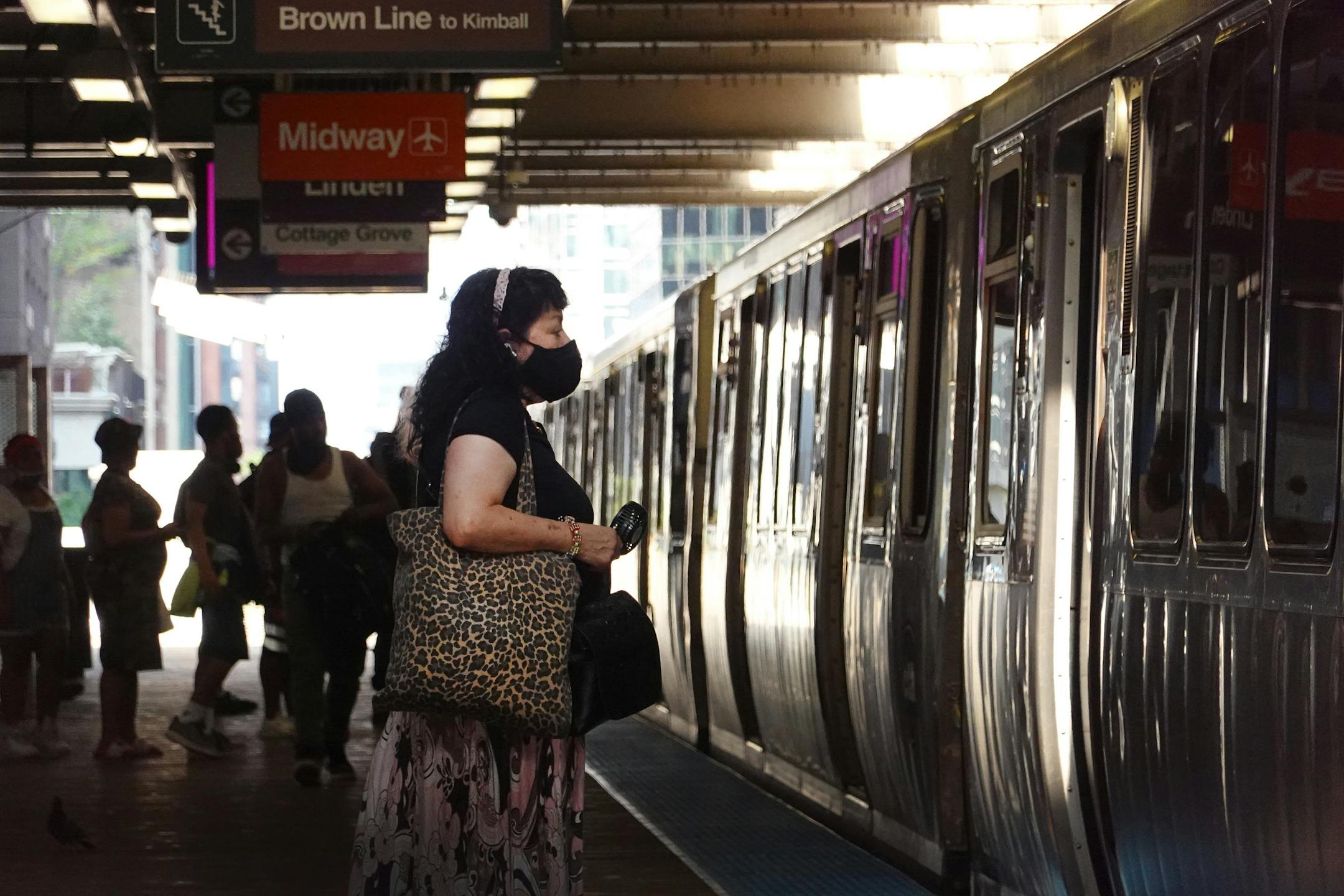 Woman in face mask waiting for train in Chicago.