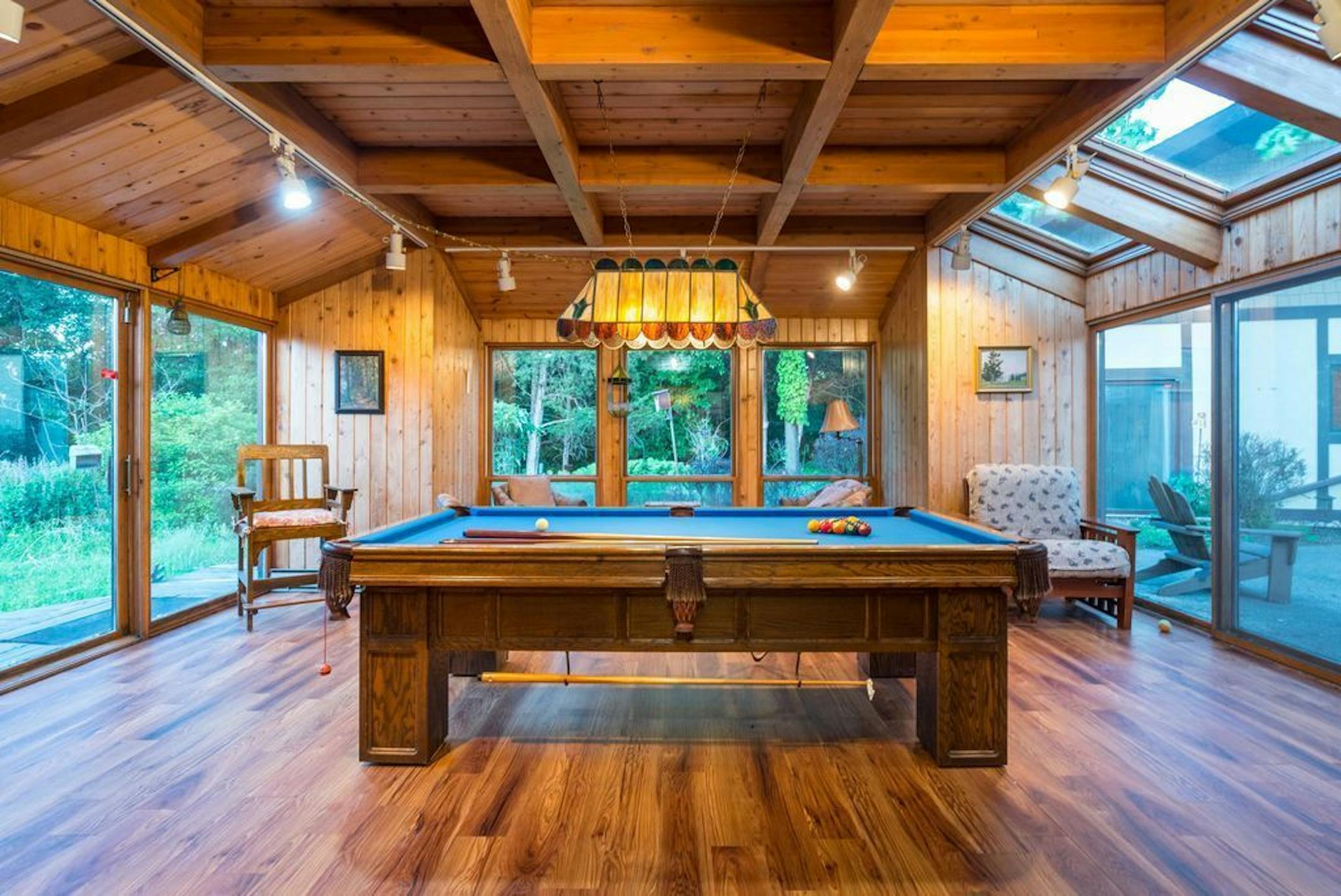 The sunroom is surrounded by gardens in the summer.