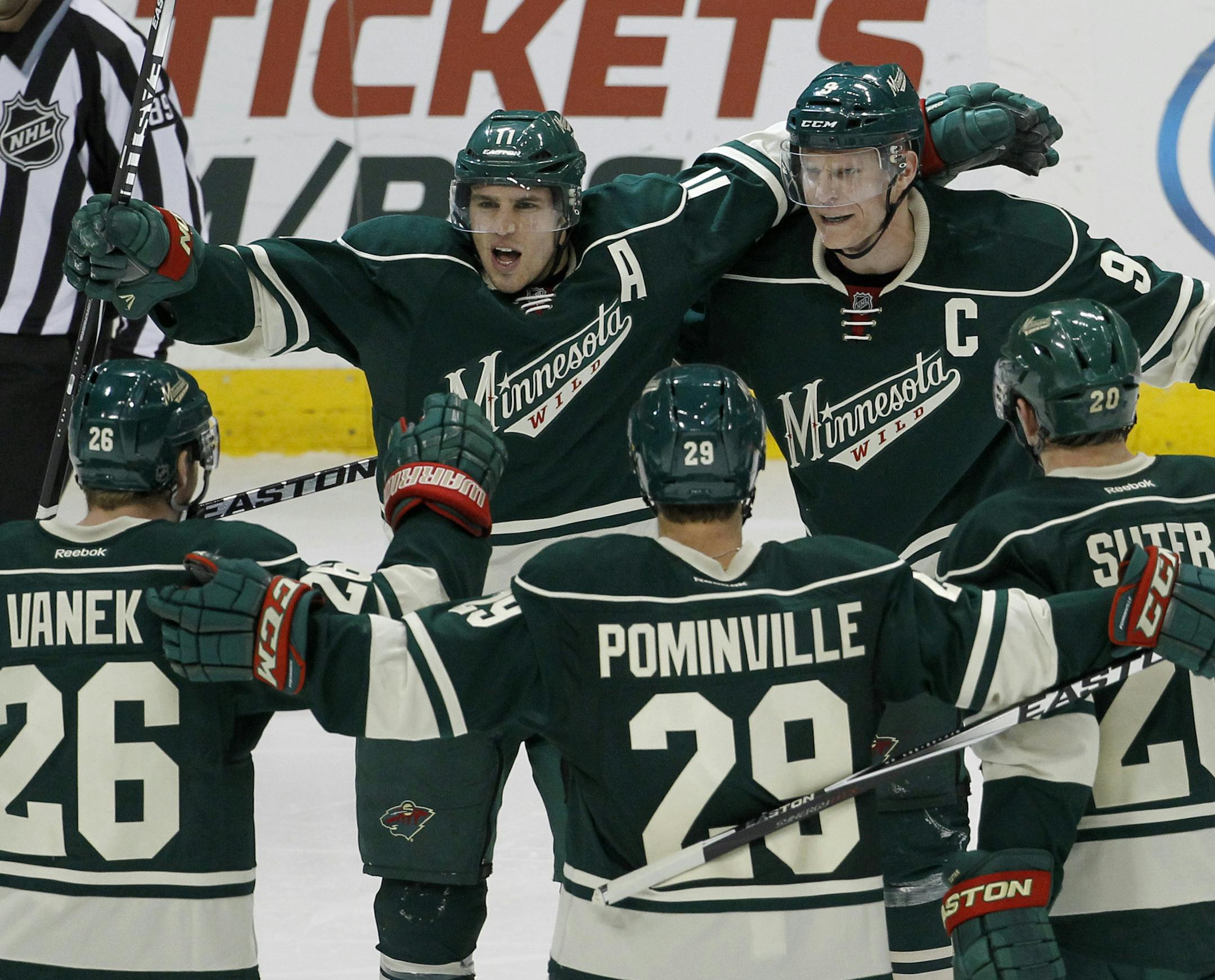Minnesota Wild's Zach Parise, top left, Thomas Vanek (26), of Austria, Jason Pominville (29) and Ryan Suter (20) celebrate with center Mikko Koivu, top right, of Finland, after Koivu's goal on Toronto Maple Leafs goalie Jonathan Bernier during the third period of an NHL hockey game in St. Paul, Minn., Friday, Jan. 2, 2015. The Wild won 3-1. (AP Photo/Ann Heisenfelt)