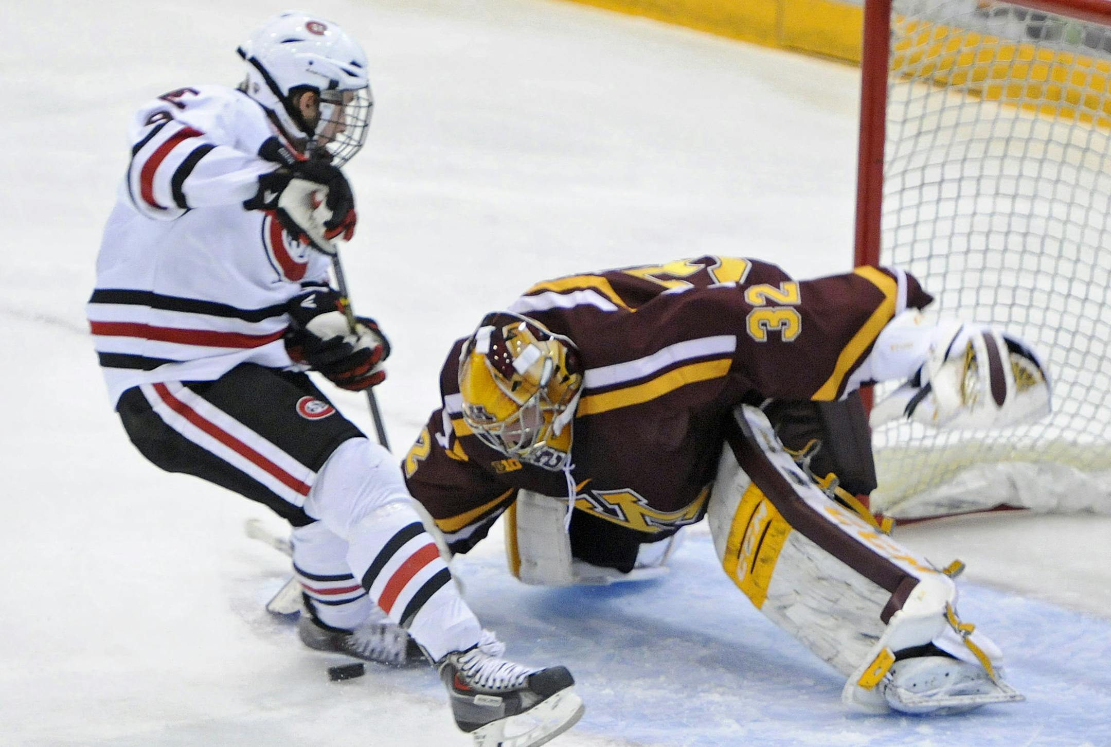 St. Cloud State's Joey Benik, left, shoots against Minnesota goaltender Adam Wilcox during the first period of a college hockey game Friday, Oct. 31, 2014, in St. Cloud, Minn. (AP Photo/The St. Cloud Times, Dave Schwarz)