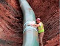 A pipe fitter lays the finishing touches to the replacement of Enbridge Energy's Line 3 crude oil pipeline stretch in Superior, Minn.
