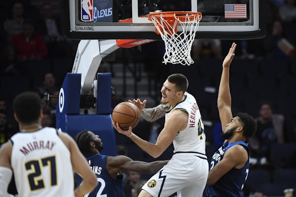 Denver Nuggets forward Juan Hernangomez (41) pulled in an offensive rebound while being challenged below the rim by Minnesota Timberwolves center Karl