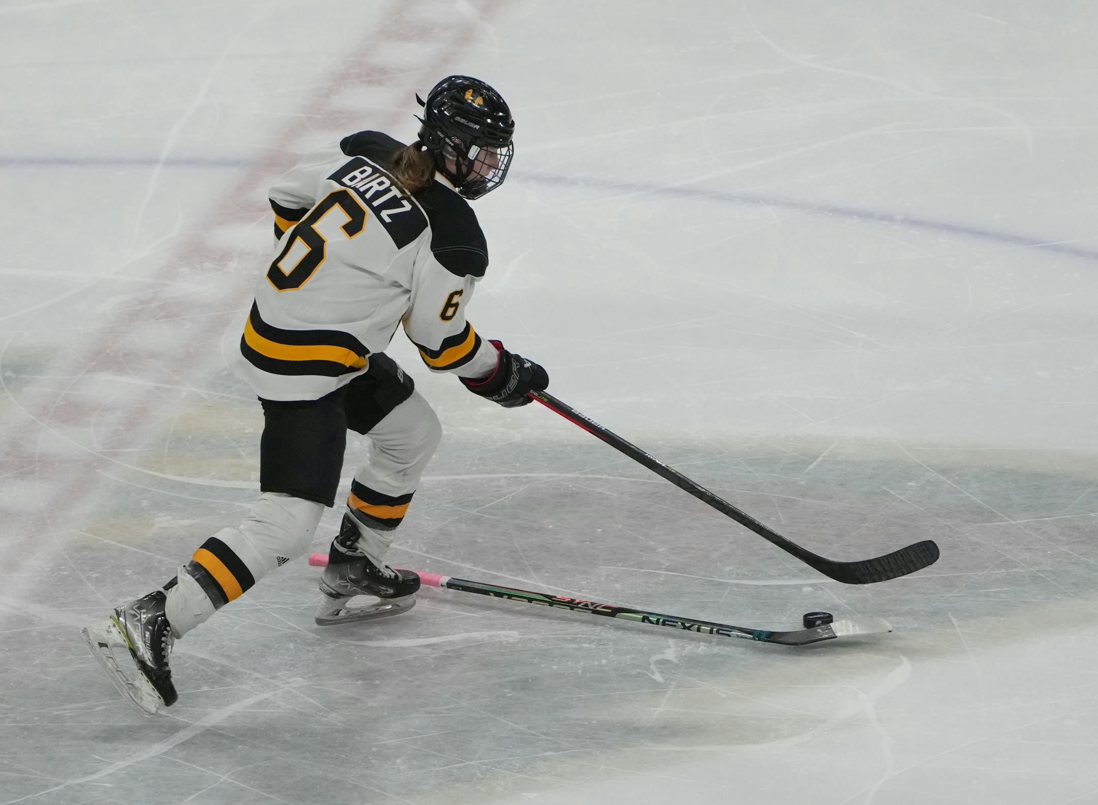 Warroad forward Rylee Bartz (6) fights off an errant stick in the second period.