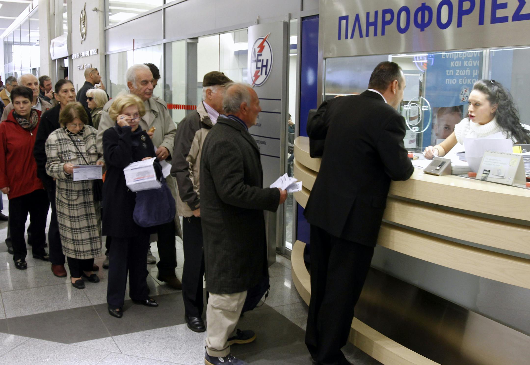 Consumers of Public Power Company, DEH, wait in a line to ask about the new property tax, which will be included in future energy bills in Athens, Oct. 31, 2011. Taking a huge political gamble, Greece's prime minister announced that his debt-strapped country will hold a referendum on the new European debt deal reached last week the first such vote in 37 years. The booth reads ''Information.'' (AP Photo/Thanassis Stavrakis)