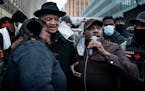 Nekima Levy Armstrong left embraced Rev. Jesse Jackson as Spike Moss spoke during a rally in Minneapolis Monday night.
