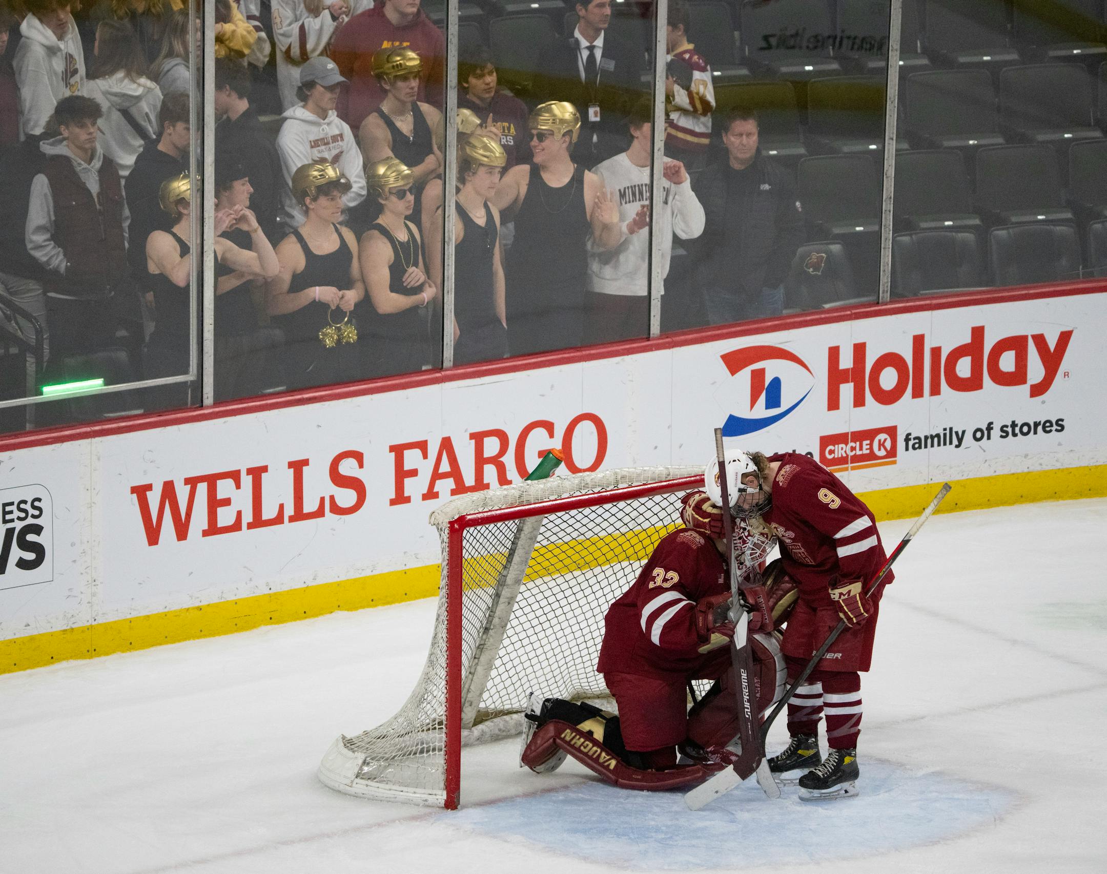 Lakeville South Cougars defenseman Camden Crawford (9) was the first to console Cougars goaltender Jack Hochsprung (33) after they were eliminated by Andover.