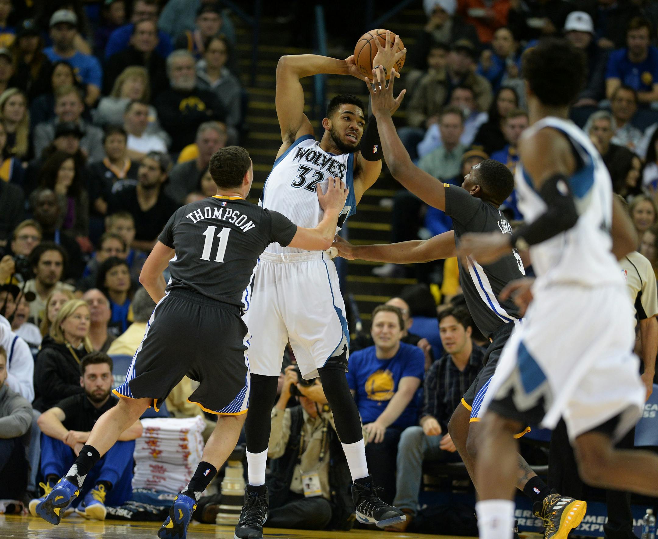 The Golden State Warriors' Klay Thompson (11) and Kevon Looney (5) pressure the Minnesota Timberwolves' Karl-Anthony Towns (32) in the first half at Oracle Arena in Oakland, Calif., on Saturday, Nov. 26, 2016. (Dan Honda/Bay Area News Group/TNS) ORG XMIT: 1193732