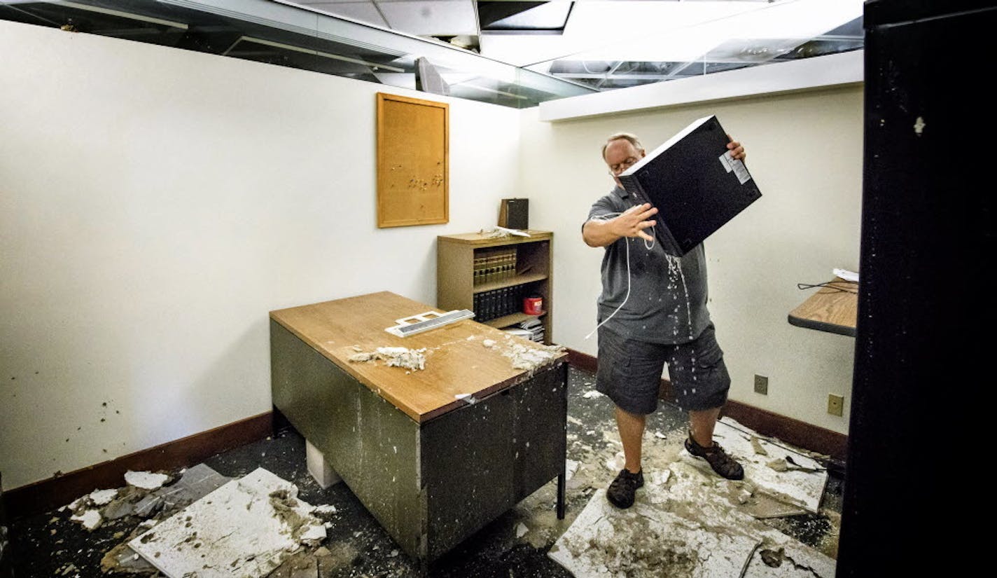 Fiscal Analyst Doug Berg poured water out of his computer on the third floor of the flooded State Office Building at the State Capitol on Thursday after a water valve there broke.