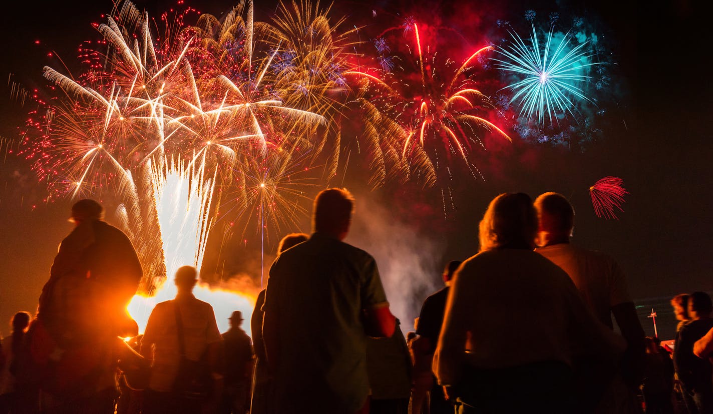 iStock
People standing in front of colorful Firework.