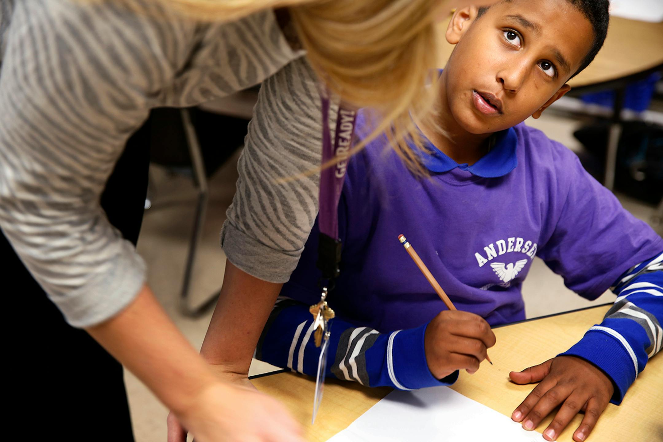 Mohamed Qasim, 10, gets help from social worker Bryssa Koppie while writing a thank you letter during an English language development lesson in Stephany Jallo's classroom at Andersen United Community School in Minneapolis. ] LEILA NAVIDI leila.navidi@startribune.com / BACKGROUND INFORMATION: Tuesday, October 21, 2014. The Minneapolis school district launched a new program last school year with sheltered classrooms and instruction in both Somali and English for new refugee arrivals, many of whom