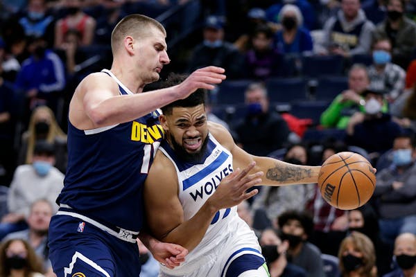 Minnesota Timberwolves center Karl-Anthony Towns drives on Denver Nuggets center Nikola Jokic (15) during the first half of an NBA basketball game Tue