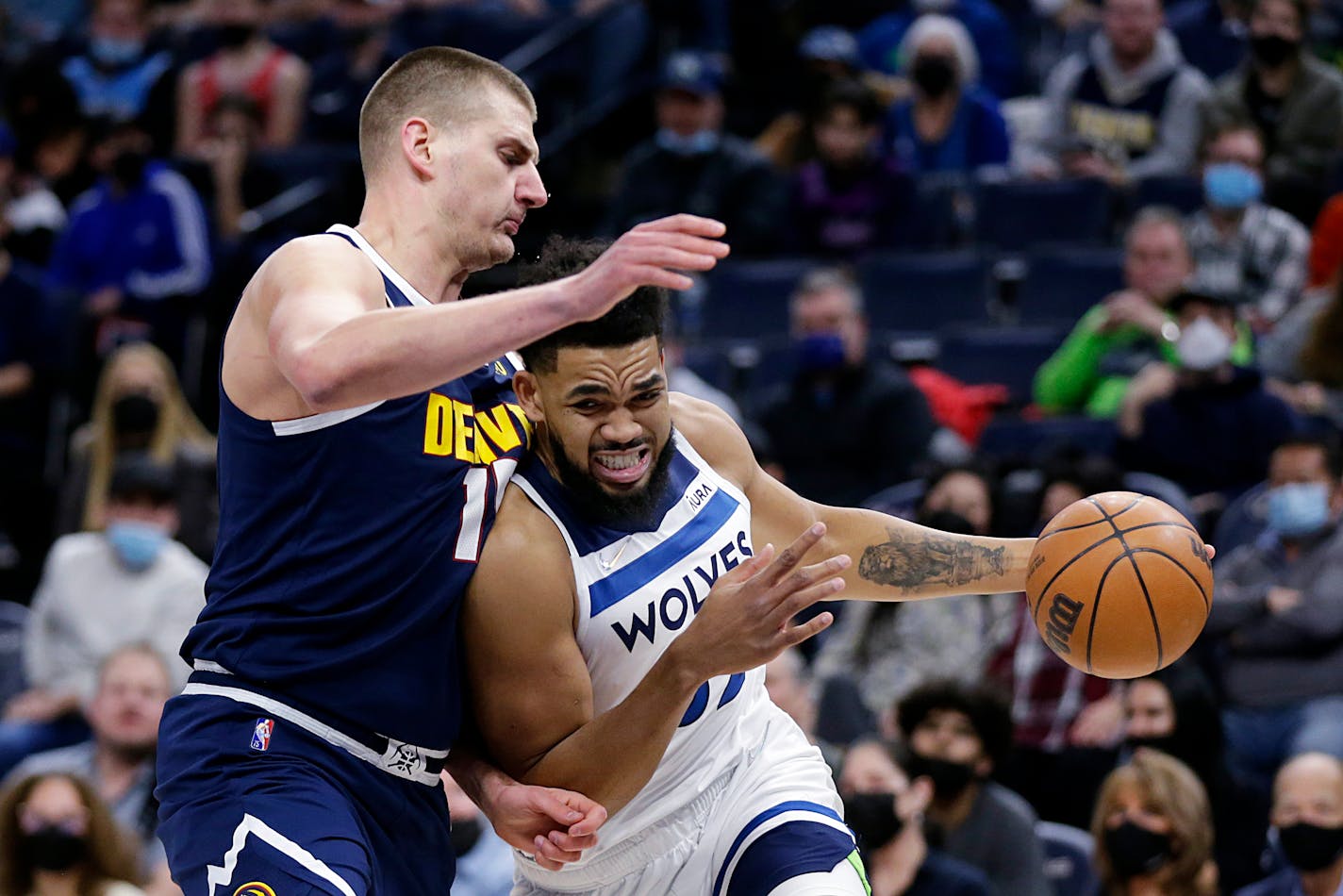 Minnesota Timberwolves center Karl-Anthony Towns drives on Denver Nuggets center Nikola Jokic (15) during the first half of an NBA basketball game Tuesday, Feb. 1, 2022, in Minneapolis. (AP Photo/Andy Clayton-King)