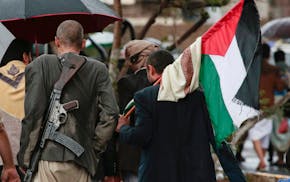 Houthi supporters carry a Palestinian flag as they walk during a rally against the U.S. and Israel and to support Palestinians in the Gaza Strip, in S