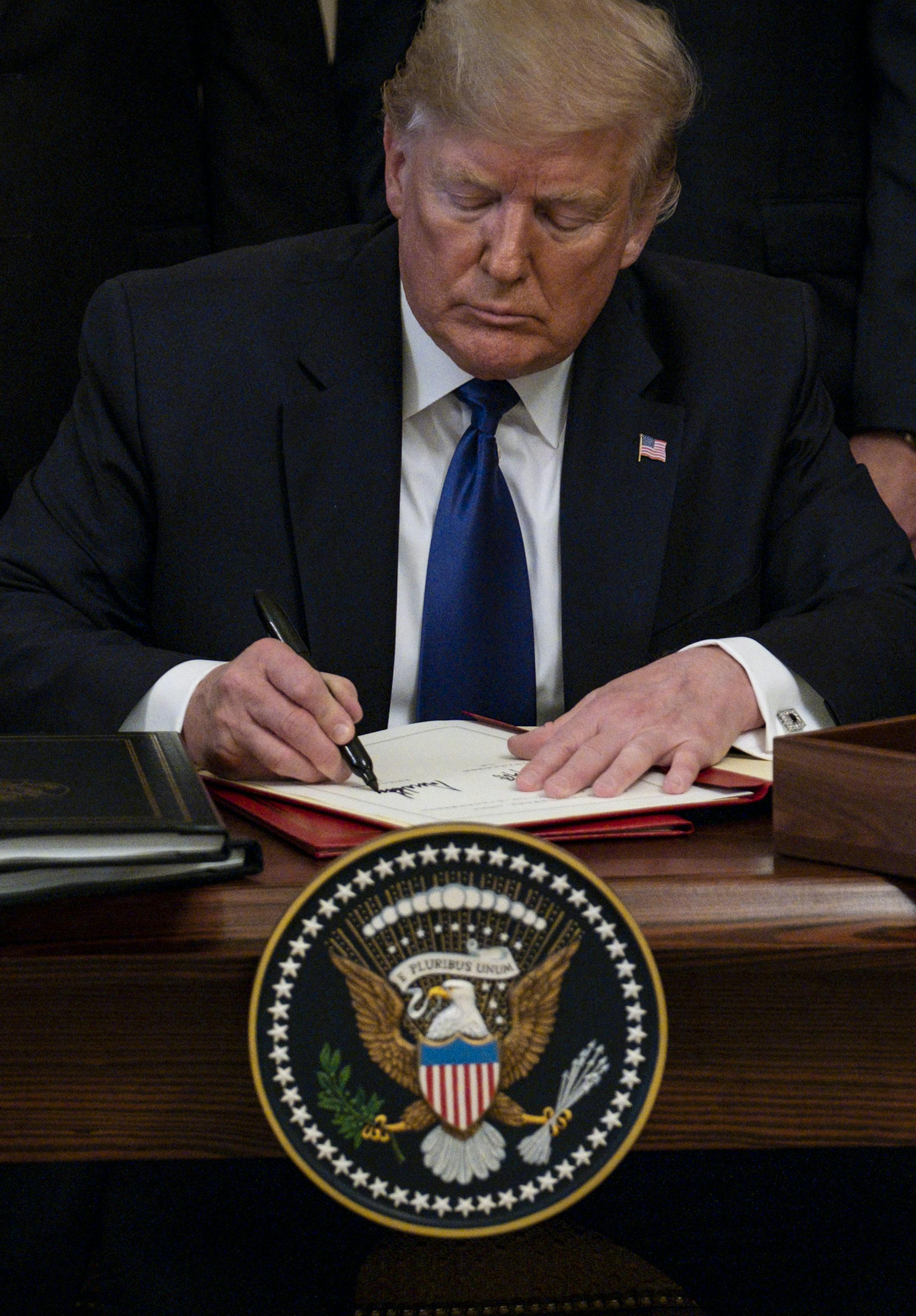 **EMBARGO: No electronic distribution, Web posting or street sales before THURSDAY 3:01 A.M. ET JAN. 16, 2020. No exceptions for any reasons. EMBARGO set by source.** President Donald Trump signs a limited trade agreement at the White House in Washington, Jan. 15, 2020. Trump administration officials say the ‘Phase 1’ deal signed Wednesday will promote growth — many economic forecasters are less optimistic. (Pete Marovich/The New York Times)
