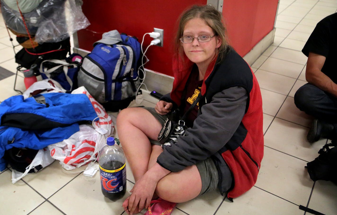 Homeless people congregate at the MOA light rail station before beginning a nightly routine of sleeping at the station and on light rail cars for those who can't get into shelters. Here, Abby Driver, 22, sits on the floor of the MOA station and charge her electronics, alongside her belongings and those of her boyfriend. On this night, Driver had been unsuccessful in her attempt to find a shelter to take her and her boyfriend Wednesday, Aug. 30, 2017, in Bloomington, MN.] DAVID JOLES &#xef; david