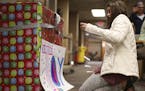 Gracie Tilney-Kaemmer, 12, taped a sign on the large box she decorated for toy donations at the International Institute of Minnesota in St. Paul Tuesd