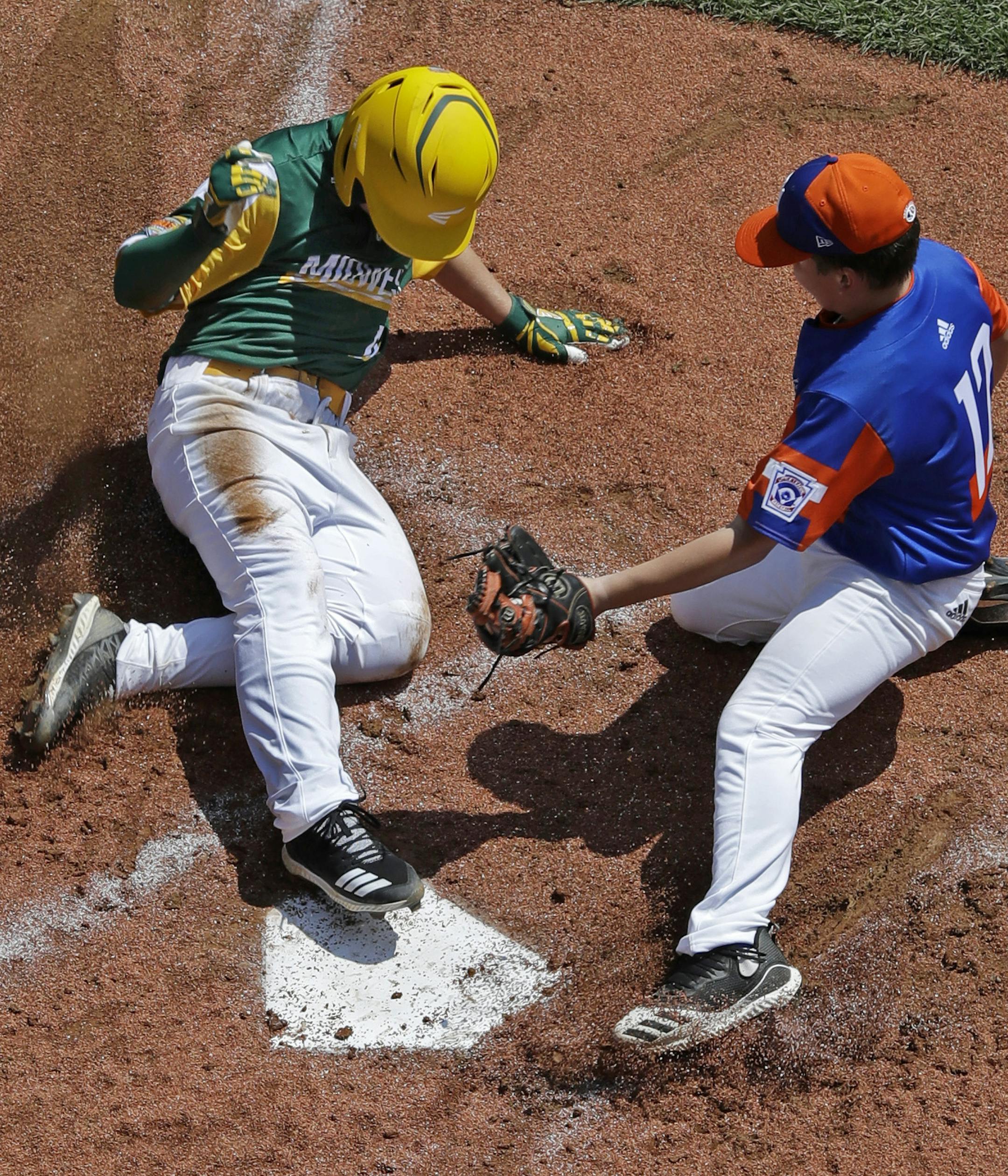 Coon Rapids, Minnesota's Tyler Phillips, left, scores ahead of the tag attempt by Bowling Green, Kentucky's Grayson Newman during the second inning of a baseball game at the Little League World Series tournament in South Williamsport, Pa., Friday, Aug. 16, 2019. Minnesota won 2-1. (AP Photo/Gene J. Puskar)