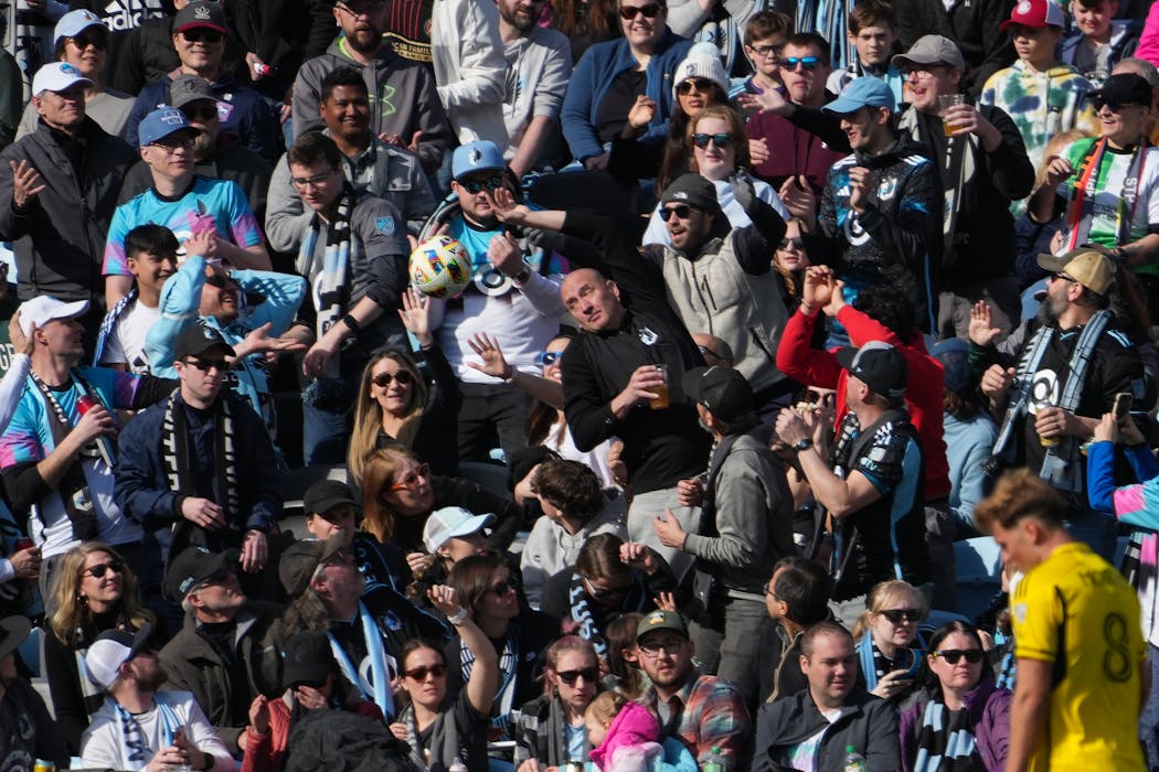 Fans protect themselves from an errant ball in the second half of a Minnesota United game against the Columbus Crew at Allianz Field in St. Paul on March 2.