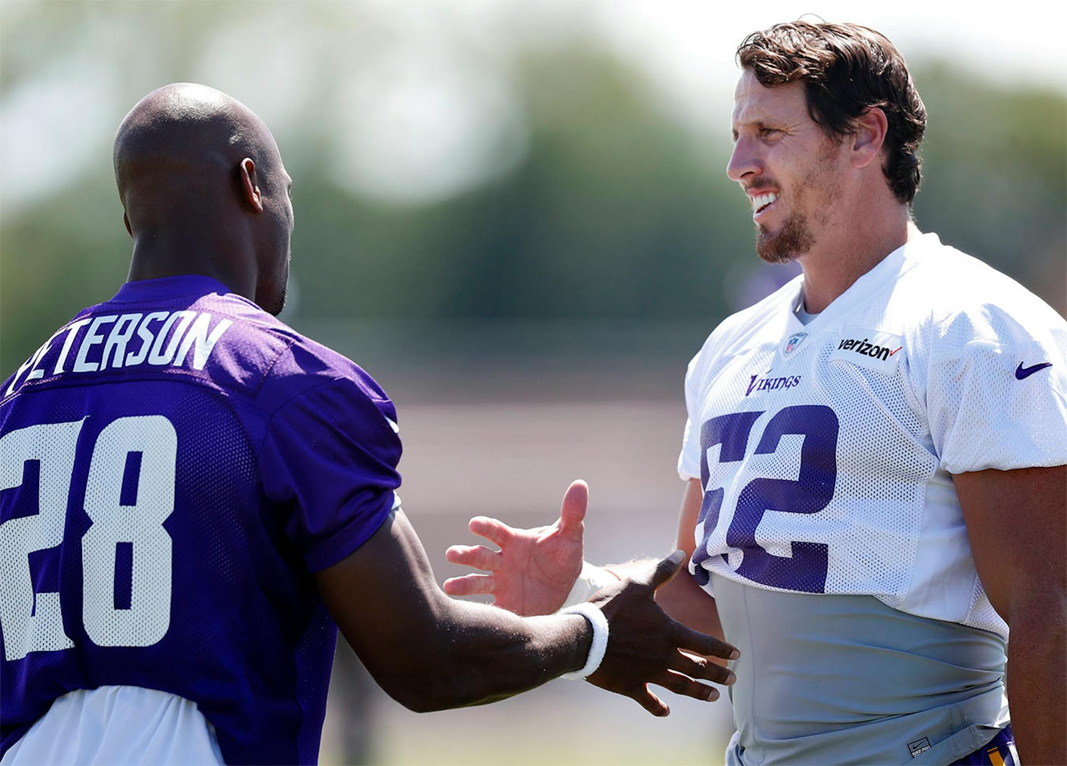 Adrian Peterson (28) and Chad Greenway (52) greeted each other before the start of the afternoon practice on the first day of training camp in Mankato.