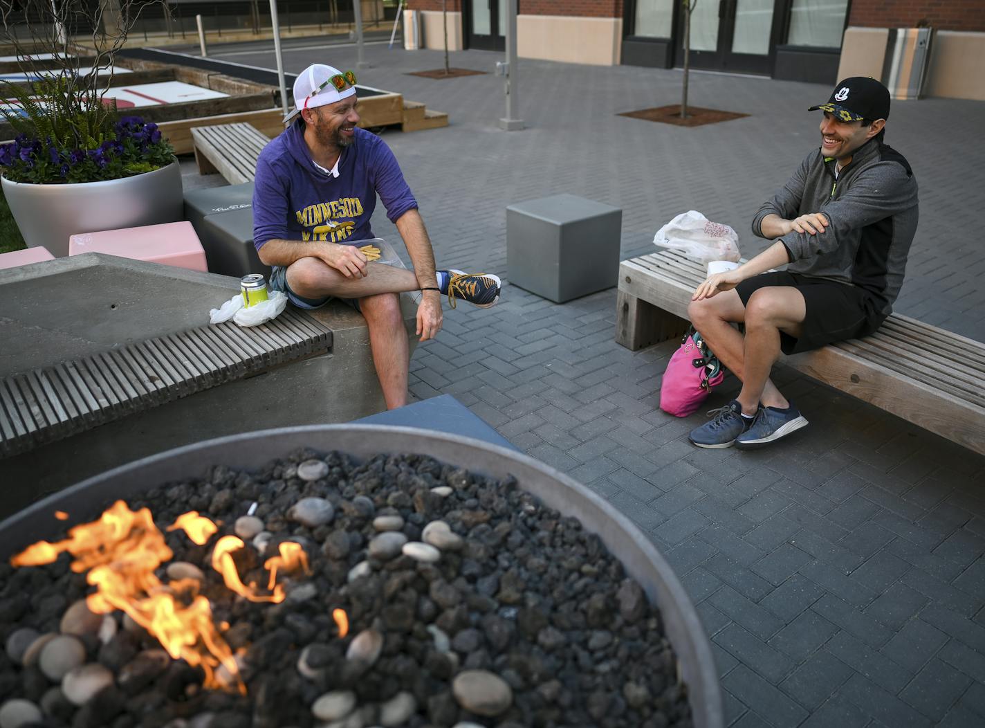 Friends Jon Feustel, left, and Mark Siebenaller, from the North Loop, drank beer and ate pizza from the Freehouse in the courtyard outside the brewpub on Wednesday night.