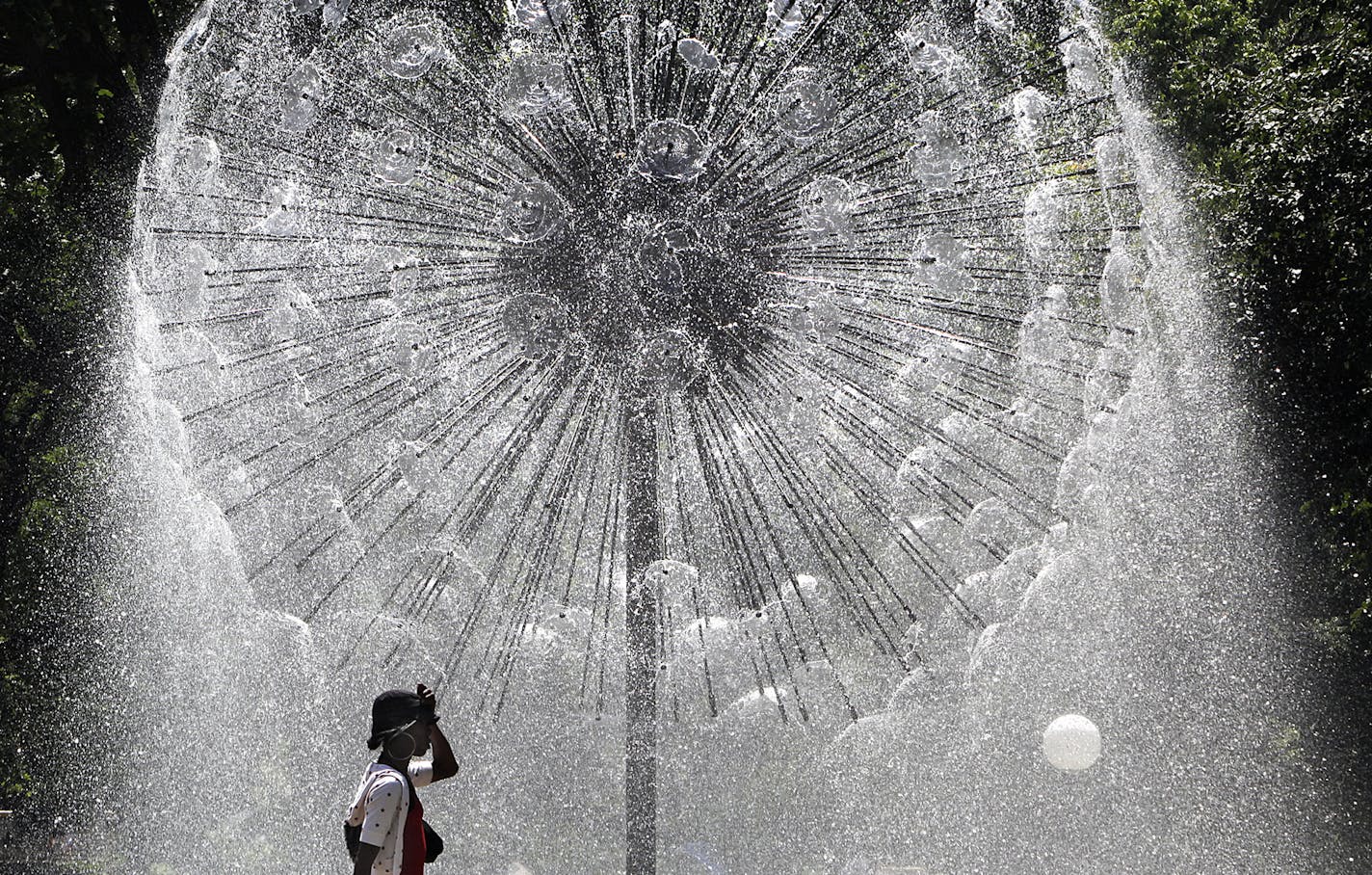 The Berger Fountain, also known as the Dandelion Fountain, in Loring Park glistened in the bright sunlight behind Chyna Porter as she enjoyed an afternoon walk.