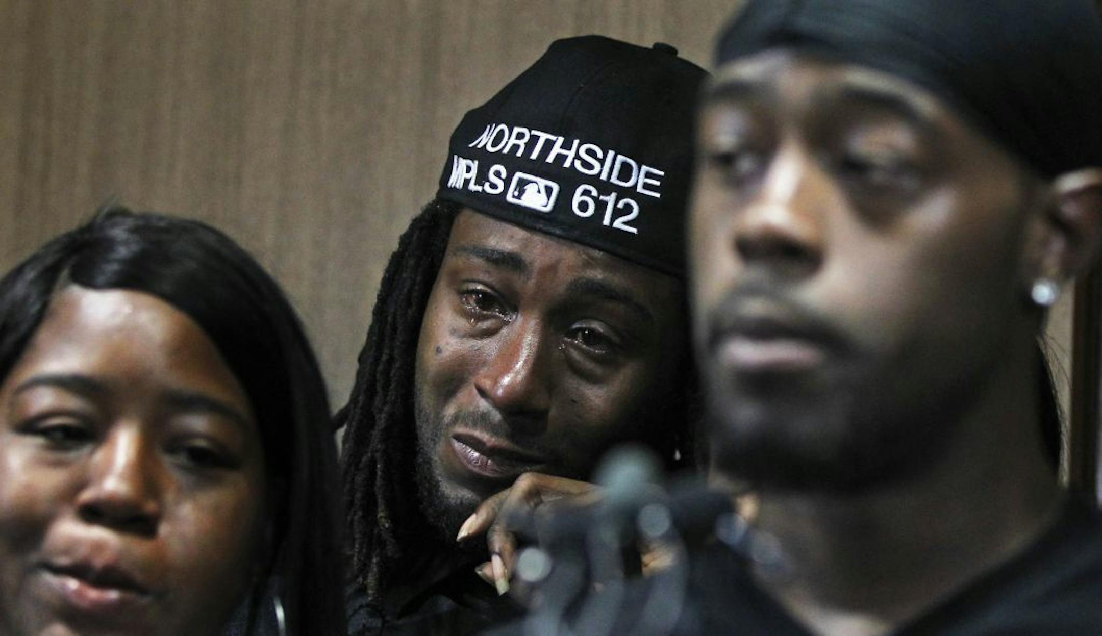 Cornelius George, right, pleaded for the violence to end: "Go to school … Be somebody." With him were his sister Shannon George and brother Lewis George.