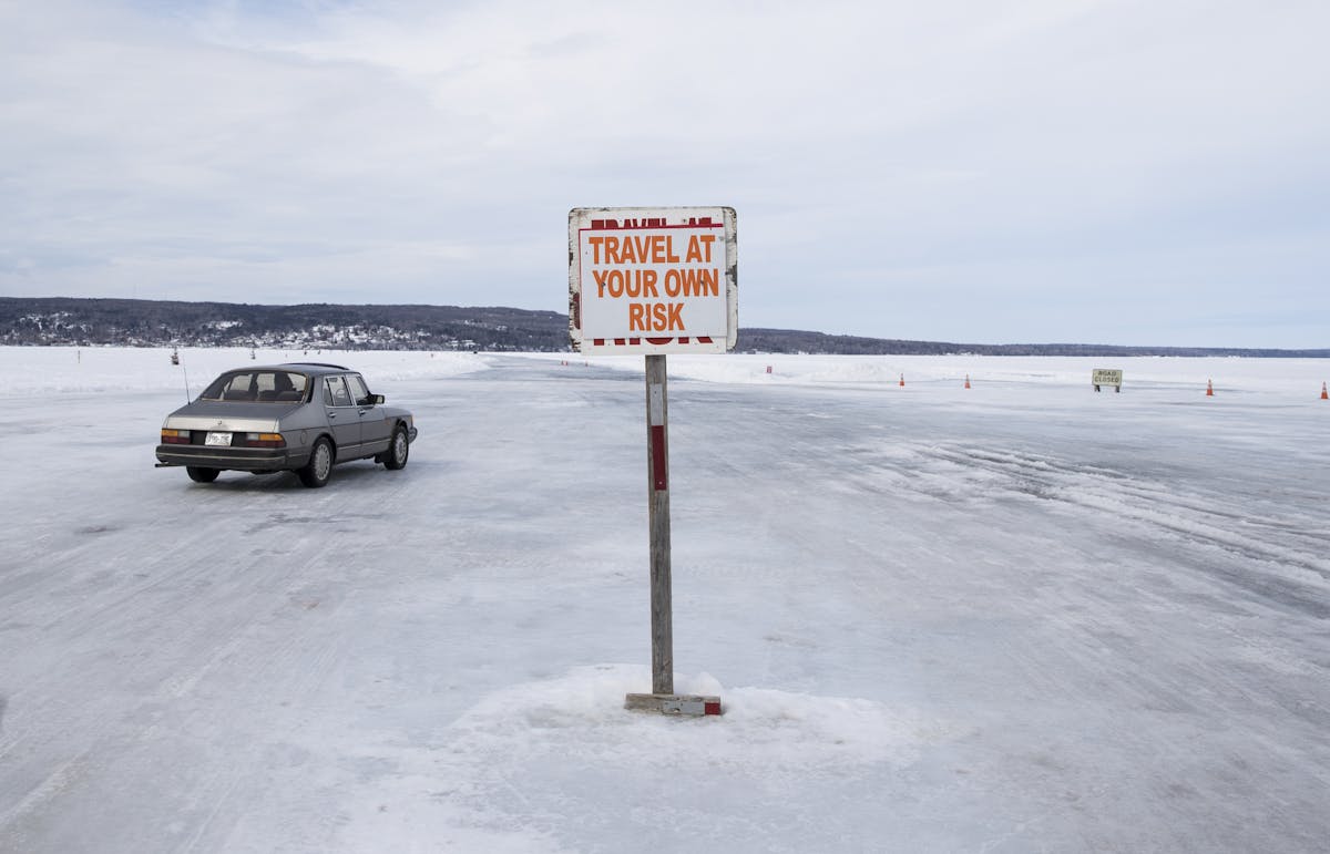 Cars traveled Monday on the ice road from Madeline Island to Bayfield, seen in the distance.