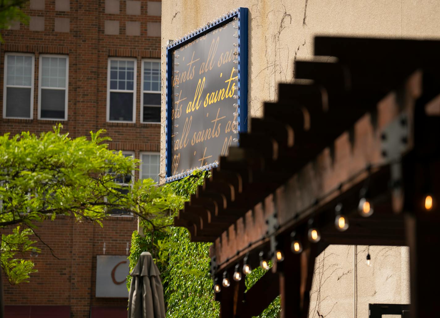 Signage for the restaurant All Saints, above the patio in their Northeast Minneapolis location.
