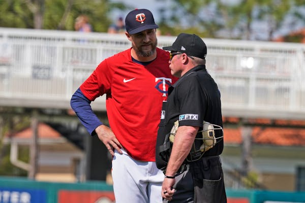 Minnesota Twins manager Rocco Baldelli, left, talks with an umpire during the ninth inning of a spring training baseball game against the Tampa Bay Ra
