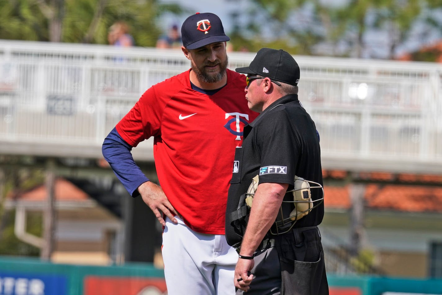 Minnesota Twins manager Rocco Baldelli, left, talks with an umpire during the ninth inning of a spring training baseball game against the Tampa Bay Rays Sunday March 20, 2022, in Fort Myers, Fla. (AP Photo/Steve Helber)