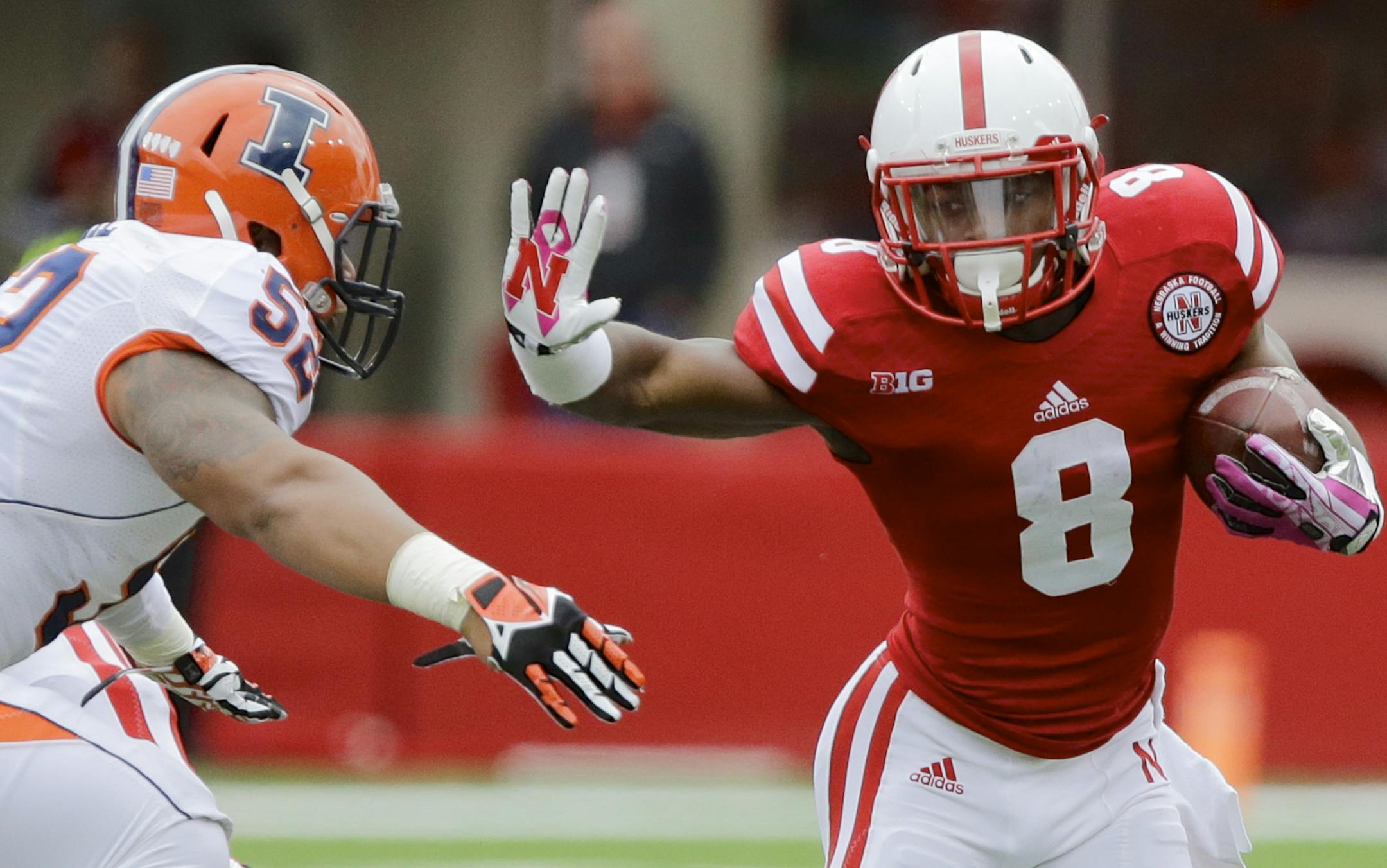 Nebraska running back Ameer Abdullah (8) runs past Illinois linebacker T.J. Neal (52) in the second half of an NCAA college football game in Lincoln, Neb., Saturday, Oct. 5, 2013. Abdullah ran for a career-high 225 yards and two touchdowns in Nebraska's 39-19 win. (AP Photo/Nati Harnik)