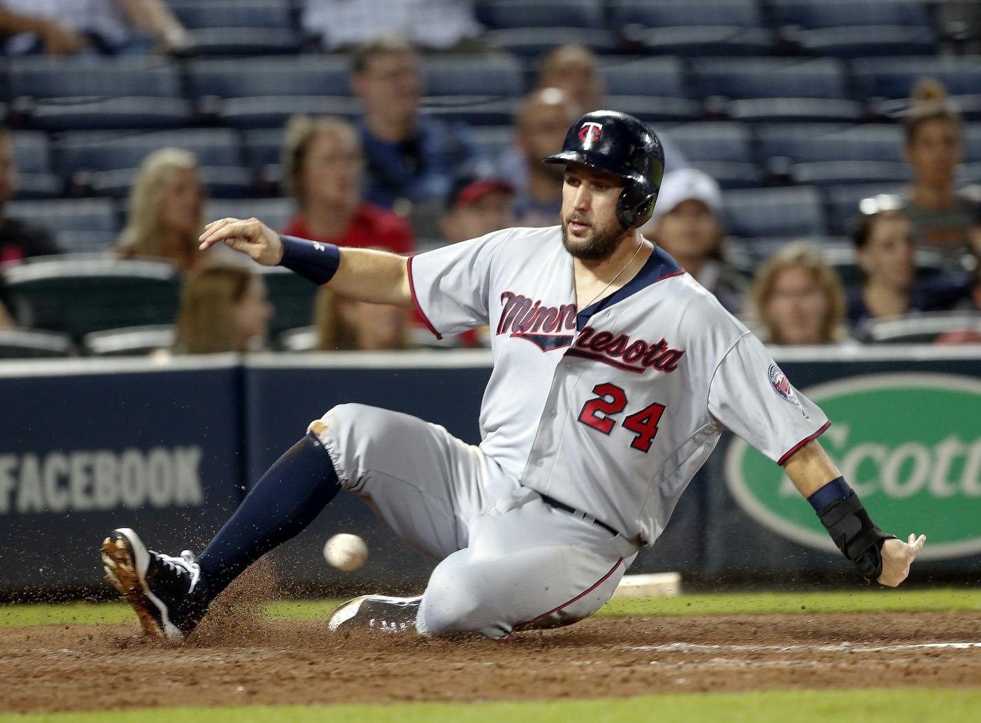 Minnesota Twins' Trevor Plouffe (24) scores on a base hit by Kurt Suzuki during the eighth inning of a baseball game against the Atlanta Braves in Atlanta, Tuesday, Aug. 16, 2016. (AP Photo/John Bazemore)