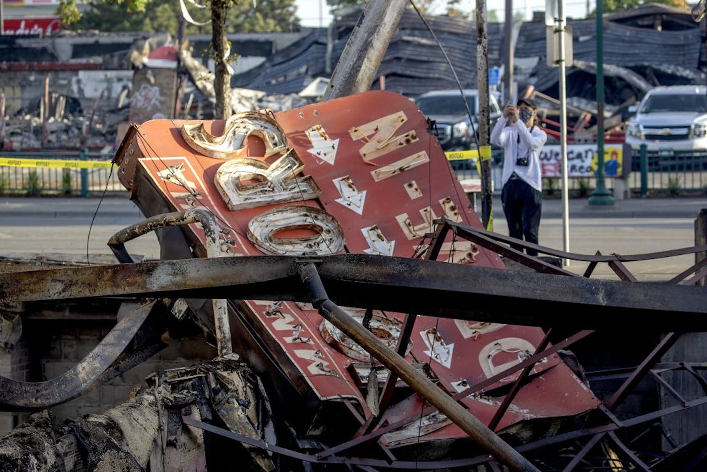 Gawkers made their way to the corner of Minnehaha Avenue and Lake St., to look over the damage to the area, Sunday, May 31, 2020 in Minneapolis, MN.