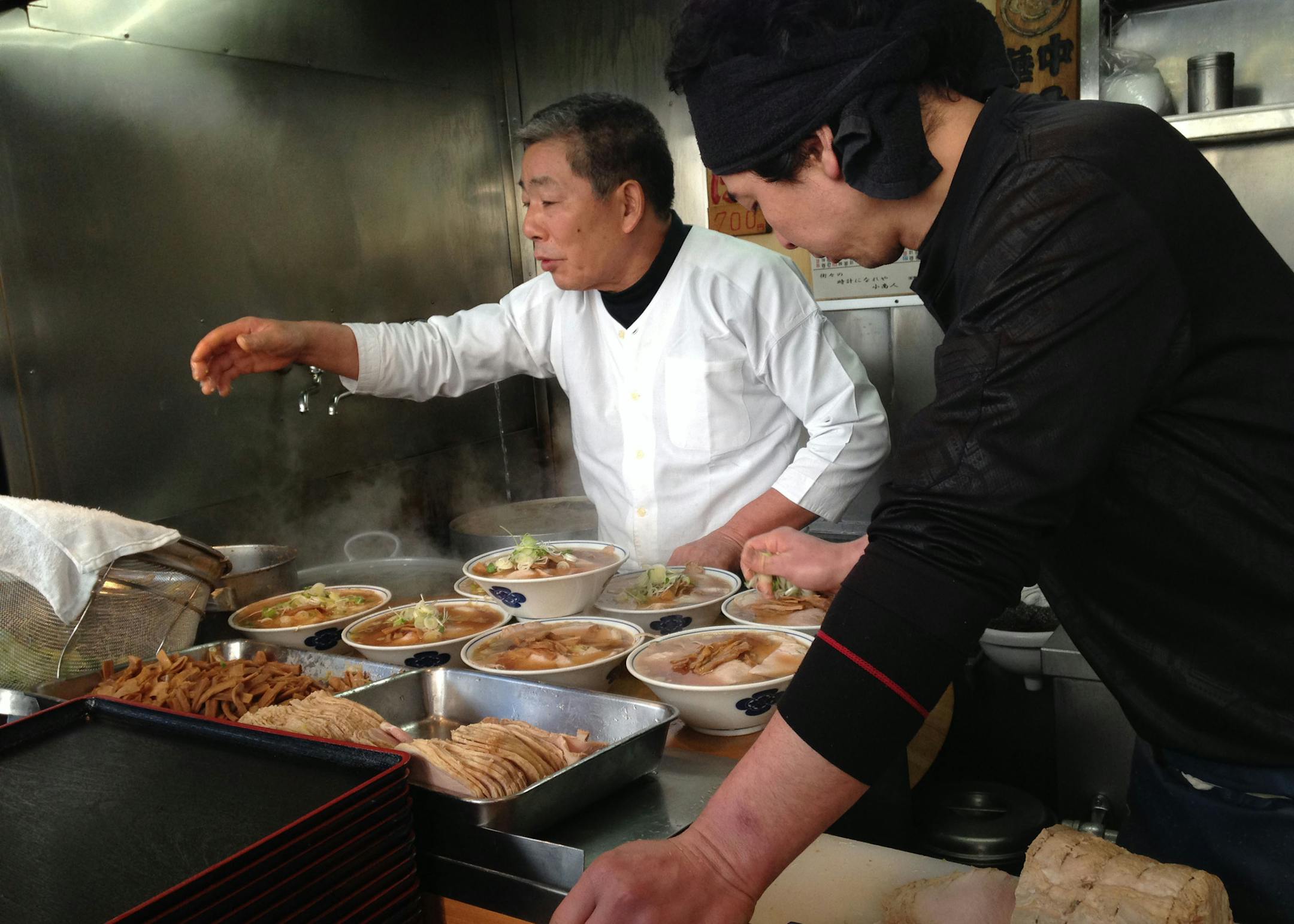 Ramen chef sprinkling onions