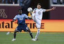 Minnesota United defender Kevin Venegas, right, and Vancouver Whitecaps forward Alphonso Davies (67) compete for the ball during the second half of an