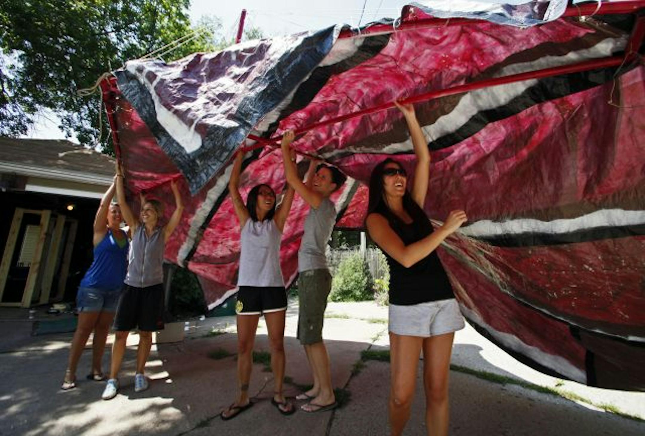 The State Fair-inspired Chicks-on-a-Stick, a group of five friends in northeast Minneapolis, are building a pickle-shaped glider with "pastrami" wings that they hope will fly when launched. Niki Larson, Joyce Roffler, Injue Cho, Helene Seymour and Breanna Peck gave the wings a test run down an alley.