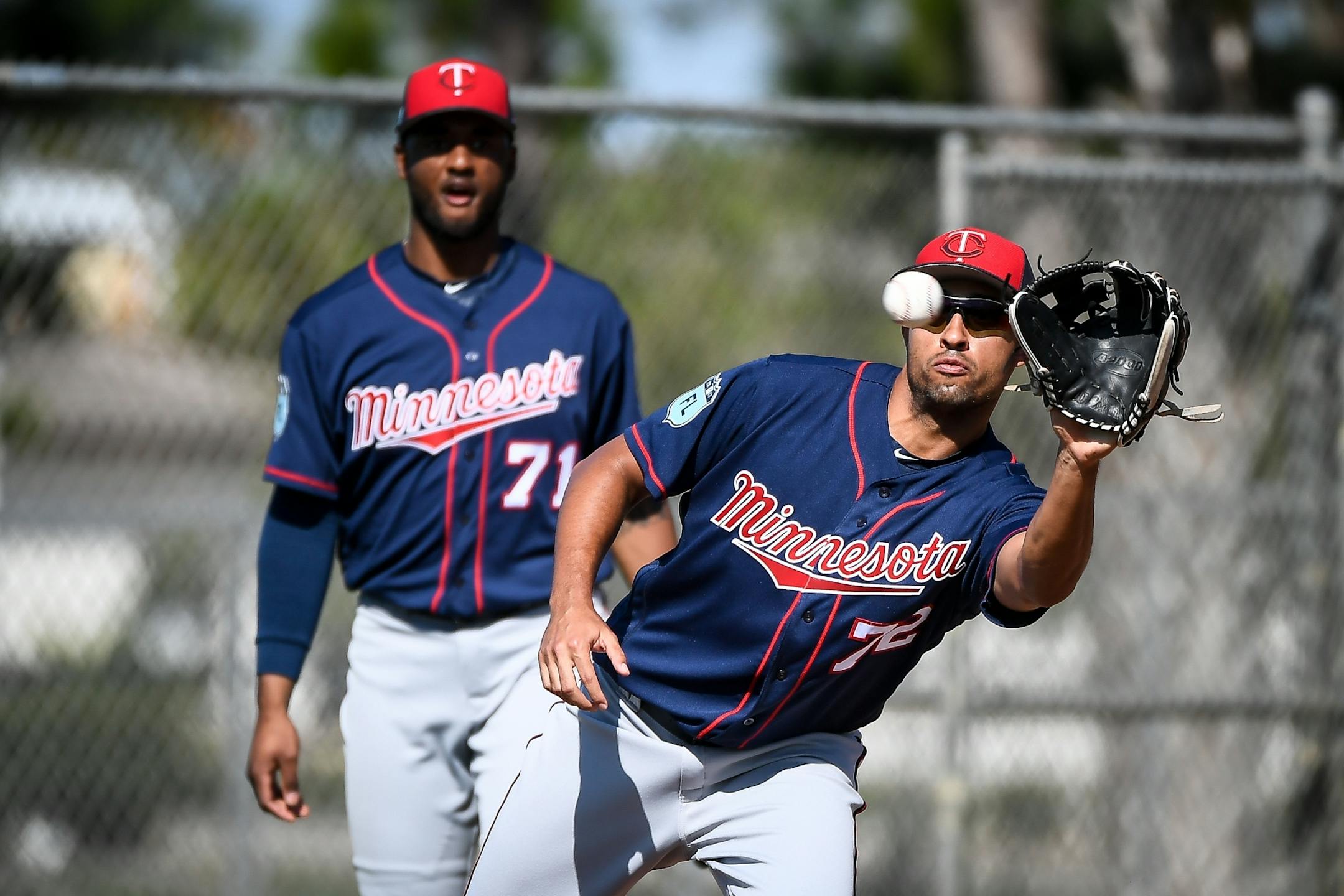 Minnesota Twins infielder Niko Goodrum (71) watched as infielder Leonardo Reginatto (72) fielded a throw meant to replicate a line drive during practice Sunday.