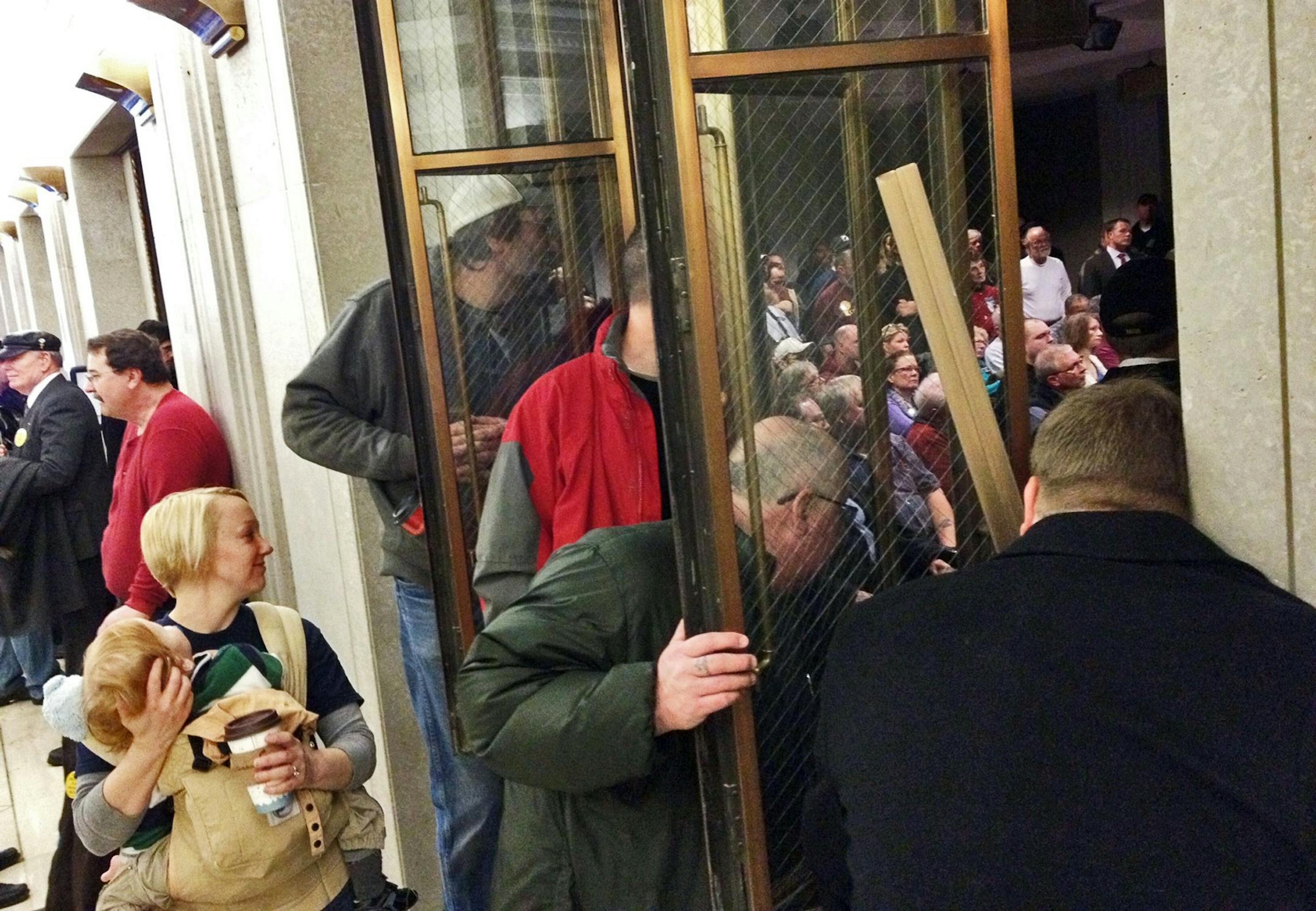 People enter an overflow room -- one of two set up -- on the first day of gun hearings at the State Capitol in St. Paul.