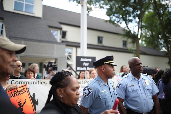 Minneapolis Police Chief Medaria Arradondo, second from right, listened as north side community members held a protest and rally at the Fourth Precinc